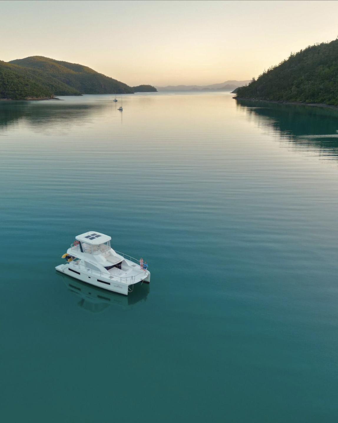Power catamaran at glassy dawn anchorage